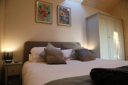 a bedroom with a large white bed with pillows at Honeysuckle in Hadleigh
