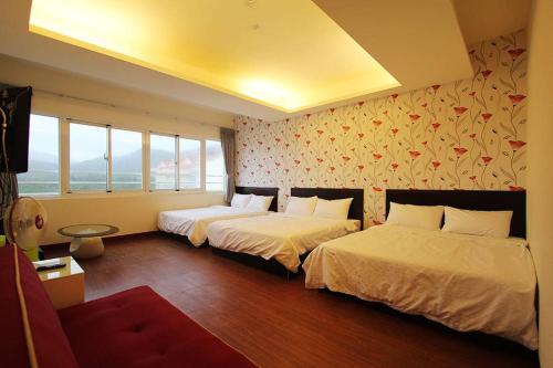 duas camas num quarto com duas janelas em Rich House B&B em Kenting