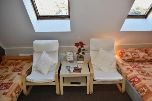a room with two chairs and a bed and a table at Pension Růžák in Růžová