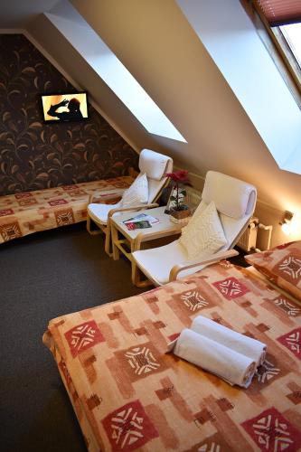 a hotel room with two beds and two chairs at Pension Růžák in Růžová