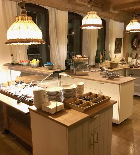 a kitchen with two pendant lights and a counter with dishes at Hotel Post mit Klimaanlage in Neckarsulm