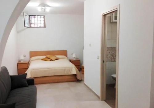 una camera con letto e divano di La Dimora dei Longobardi Studio Apartment a Salerno