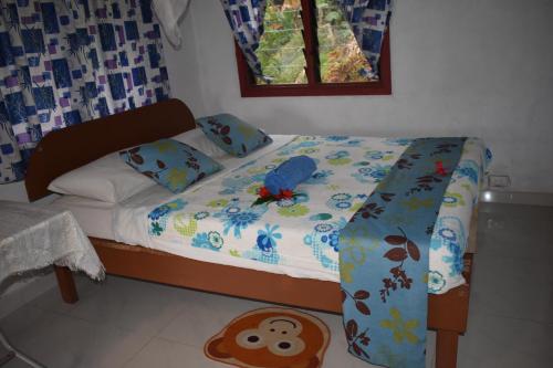 ein kleines Bett in einem Schlafzimmer mit einer Affendecke und Kissen in der Unterkunft Alofa Beach Bungalows in Insel Tanna