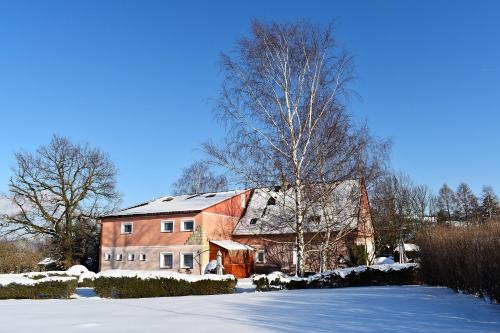a large red barn with snow on the ground at Pension Růžák in Růžová