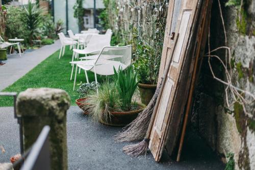 a row of white chairs and plants on a sidewalk at Rosa Et Al Townhouse in Porto