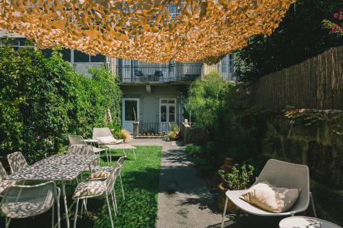 a patio with tables and chairs in a garden at Rosa Et Al Townhouse in Porto