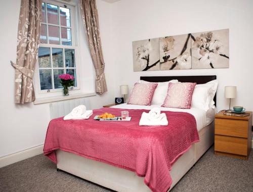 a bedroom with a bed with a red blanket at Apt 2, Trafalgar Square 2nd Floor by Indigo Flats in London