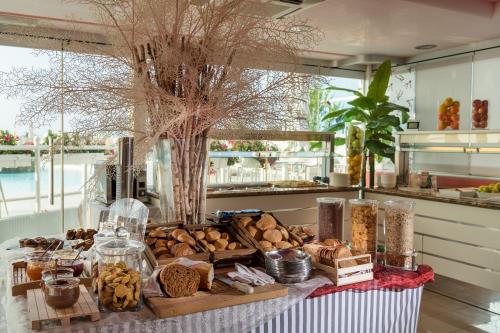 a table topped with lots of different types of bread at Baia del Mar Beach Boutique Hotel in Lido di Jesolo