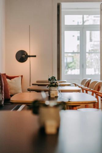 a room with tables and chairs and a window at Rosa Et Al Townhouse in Porto