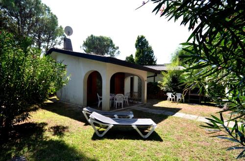 podwórze z fotelem i domem w obiekcie Ville Park Hotel w Bibione