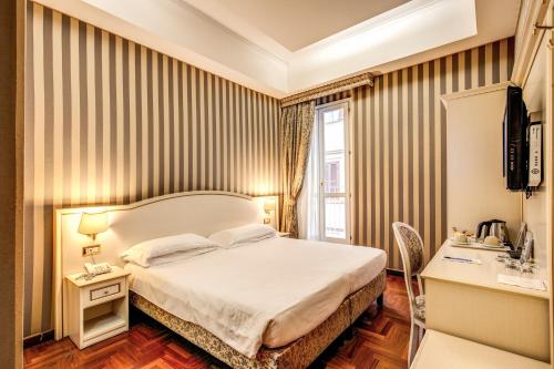 um quarto de hotel com uma cama e uma secretária em Trevi 41 Hotel em Roma