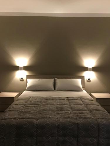una camera da letto con un letto con due luci sopra di Cà Risorta Stanze a Sona