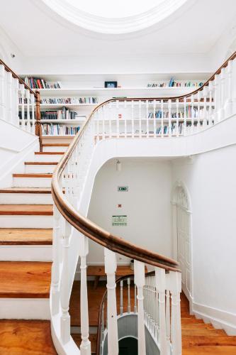 a spiral staircase in a house with books at Rosa Et Al Townhouse in Porto