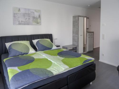 a bedroom with a bed with a green and blue comforter at Ferienapartment im Augustinus Park in Trier