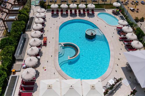 an overhead view of a swimming pool with umbrellas at Baia del Mar Beach Boutique Hotel in Lido di Jesolo