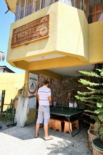 a man standing in front of a ping pong table at Backpacker's Hostel Iquique in Iquique
