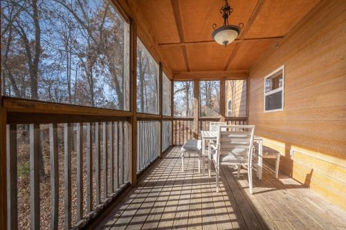 a screened in porch with a table and chairs on it at The Lodges at Table Rock in Branson
