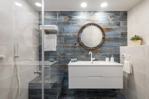 a bathroom with a white sink and a mirror at Herzliya Marina Lagoon Apartment in Herzliyya B