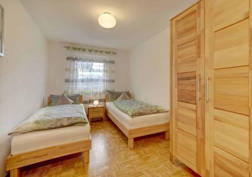 a bedroom with two beds and a sliding door at Ferienwohnung Lankl im Bayerischen Wald in Röhrnbach