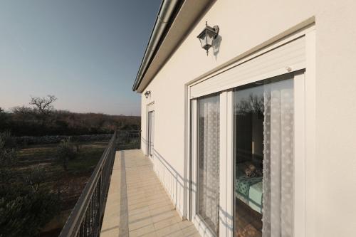 a balcony of a house with a large window at Holiday Home Hrast in Debeljak