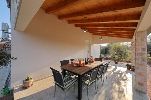a dining room with a table and chairs on a patio at Holiday Home Hrast in Debeljak