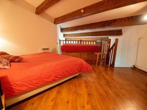 a bedroom with an orange bed and a wooden floor at LE MONTAGNARD in Isola 2000