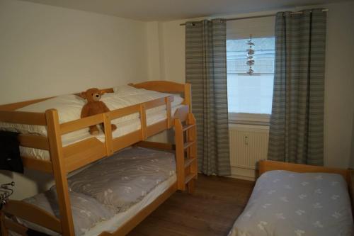 a bedroom with two bunk beds with a teddy bear on top at Zum Strandkorb in Zingst