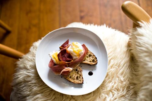 a plate with a breakfast sandwich on a table at Rosa Et Al Townhouse in Porto