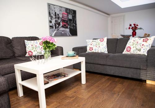 a living room with a couch and a table at Apt 3, Trafalgar Sq Duplex, 3rd & 4th floor by Indigo Flats in London