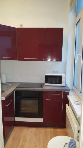 a kitchen with brown cabinets and a microwave at Central Yellow Apartment in Brussels