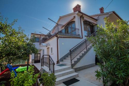 a white house with stairs in front of it at Apartman Ana in Krk