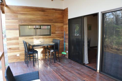 a dining room with a wooden wall and a table and chairs at CASA NATURaL in Brasilito