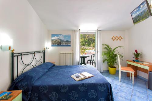 um quarto com uma cama azul com um livro em Hotel Terme Miramonte e Mare em Ischia