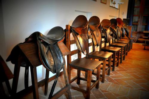 a row of wooden chairs with a hat on them at Rustico del Conero in Camerano