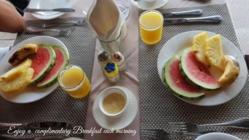 een tafel met twee borden eten en twee kopjes koffie bij Menai Bay Beach Bungalows in Unguja Ukuu