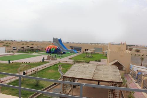 uma vista para um parque infantil com escorrega em بوابة الرمال السياحية Tourism sands gate em Al Wāşil
