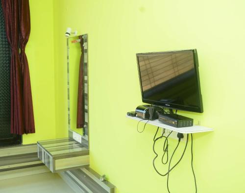 a television sitting on a shelf in a room at Shreyas Guest house - Tatkare Villa in Kashid