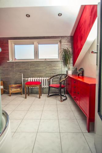 a kitchen with red cabinets and a table and chairs at Agrowczasy in Wola Piotrowa