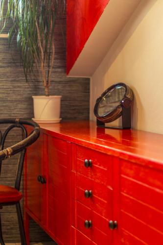 a red dresser with a mirror and a plant on it at Agrowczasy in Wola Piotrowa