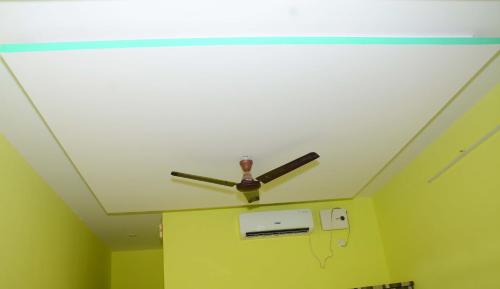 a ceiling fan in a room with a green wall at Shreyas Guest house - Tatkare Villa in Kashid