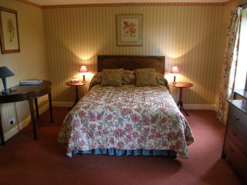 a bedroom with a bed with two tables and two lamps at Threeways House in Daventry