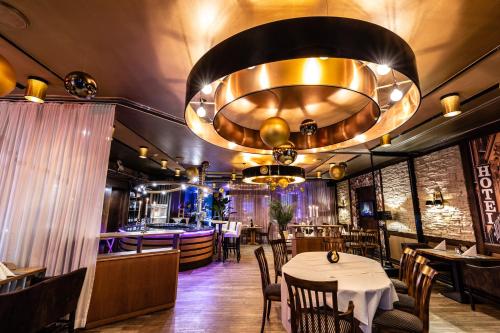 a dining room with tables and a large chandelier at Akzent Hotel Tietmeyer & Cross Side in Schöppingen