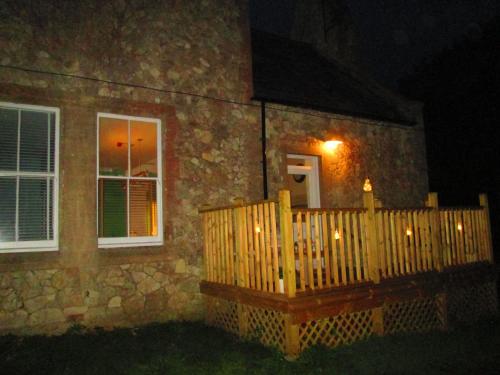 a house with a wooden fence and a porch at night at Weston Manor in Freshwater