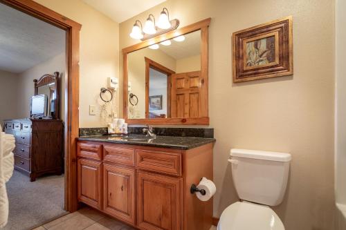 a bathroom with a toilet and a sink and a mirror at The Lodges at Table Rock in Branson