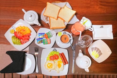 una mesa con platos de desayuno y un vaso de zumo en Asian Grand Hotel, en Negombo