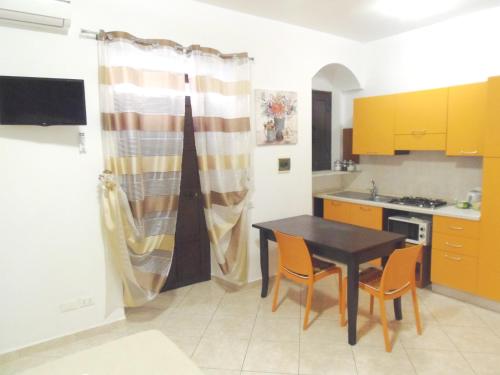 a kitchen with a table and chairs in a kitchen at IN CENTRO ROOMS Vicino Cefalù SELF-CHEK-IN in Campofelice di Roccella
