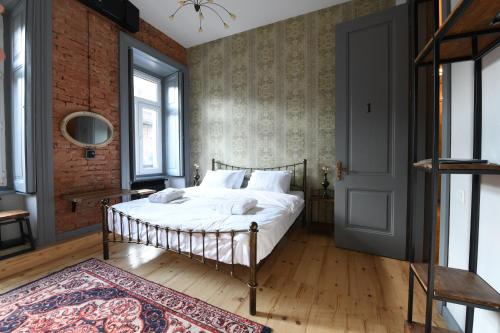 a bedroom with a bed and a brick wall at Jardin Vera in Tbilisi City