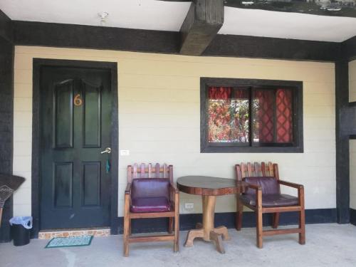 two chairs and a table in front of a house at Buenaventura Beachresort in Nauhang