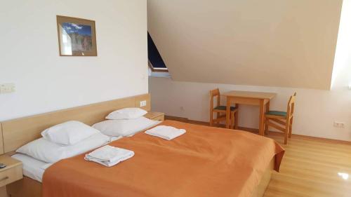 a bedroom with a bed with two towels on it at Lilla Wellnessapartman in Zalakaros