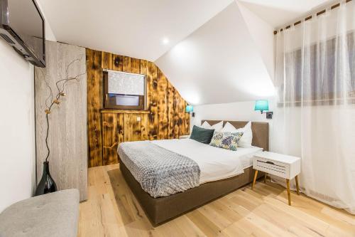 a bedroom with a bed with a wooden wall at Hotel Pok Garni in Brezovica